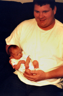 My nephew Brandon, the proud father (gulp!) holds a sleepy one-week old Katelyn Marie. 